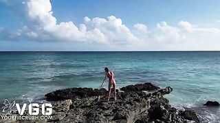 A young and sexy girl is playing on a naked beach