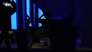 A girl is trying on clothes in the fitting room, while a guy is filming her