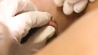 A hot brunette plays with her new clit piercing using a toy