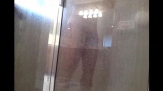 A guy washes himself under a hidden camera in the shower