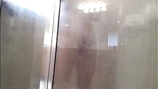 A guy washes himself under a hidden camera in the shower