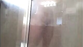 A guy washes himself under a hidden camera in the shower