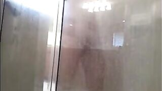 A guy washes himself under a hidden camera in the shower