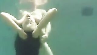 Sex on the ocean floor with a busty brunette, showcasing her fake assets