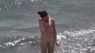 A couple of free-spirited nudists are having fun on the beach