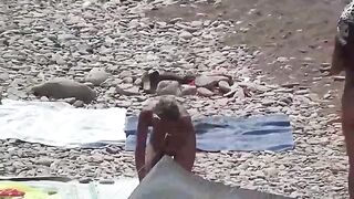 A couple of free-spirited nudists are having fun on the beach