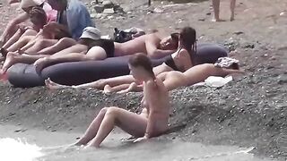 A couple of free-spirited nudists are having fun on the beach