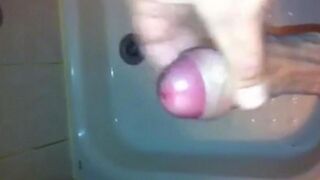 The kid masturbates his dick with his hand while taking a shower