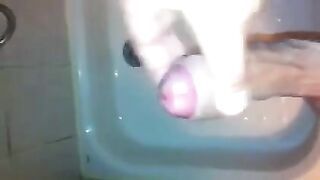 The kid masturbates his dick with his hand while taking a shower