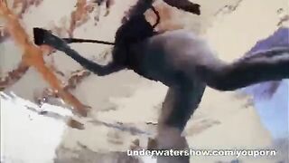 A sexy girl is floating naked in the swimming pool