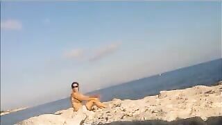 A girl has a sunbath in the nude on the beautiful beach