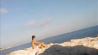 A girl has a sunbath in the nude on the beautiful beach