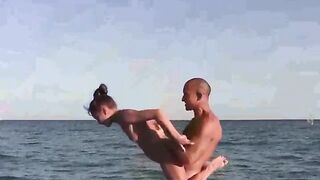 Beach naked acrobats show their skills in the nude on the ocean