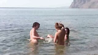 A group of nudists enjoy each other without any clothes on the beach