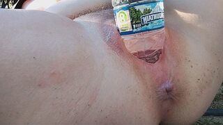 A woman reached the peak of pleasure while indulging in outdoor self-pleasure with a water bottle